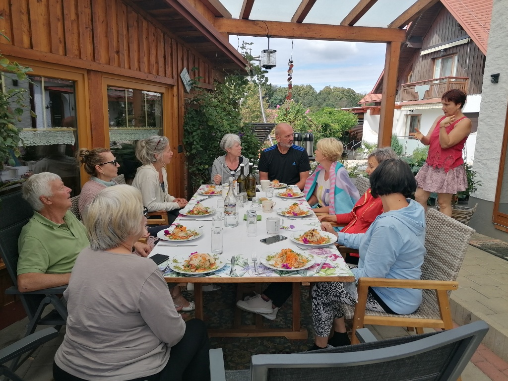 Gruppe sitzt am Esstisch im Garten