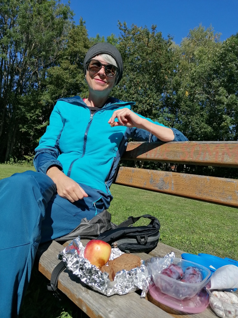 Schöne Frau mit Sonnenbrille sitzt auf einer Bank