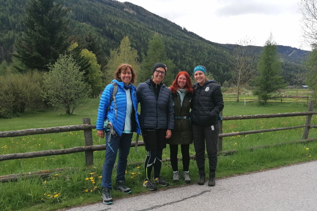 4 Frauen, im Hintergrund Wiese und Berge