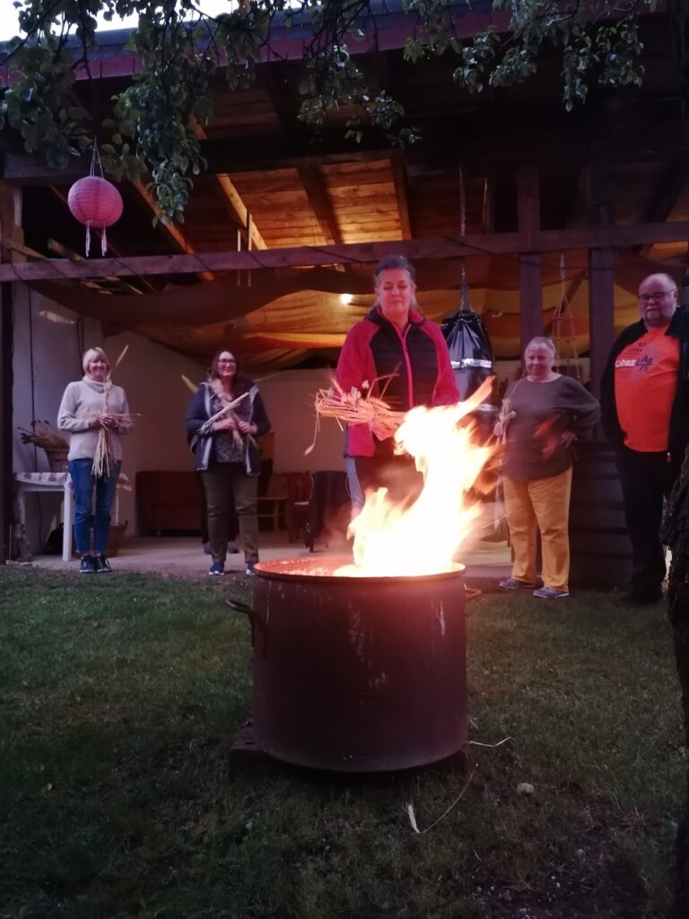 Loderndes Feuer, im HIntergrund die Teiilnehmer-Gruppe