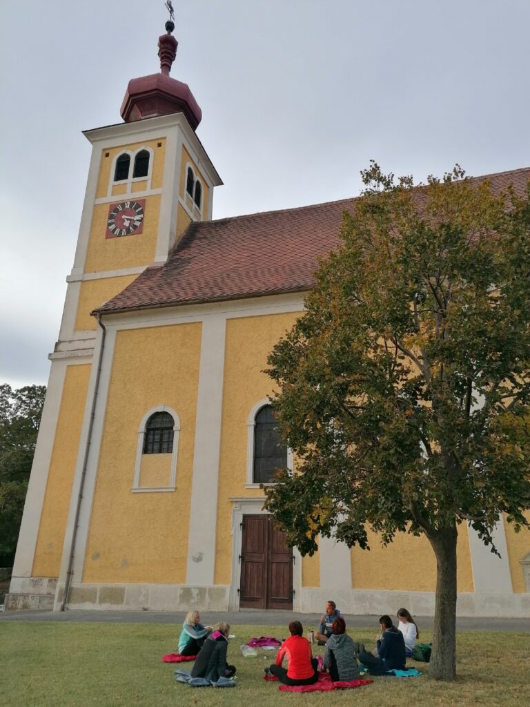 Donnerskirchner Bergkirche, davor sitzt auf der Wiese die Fastengruppe und löffelt ihre letzte Fastensuppe