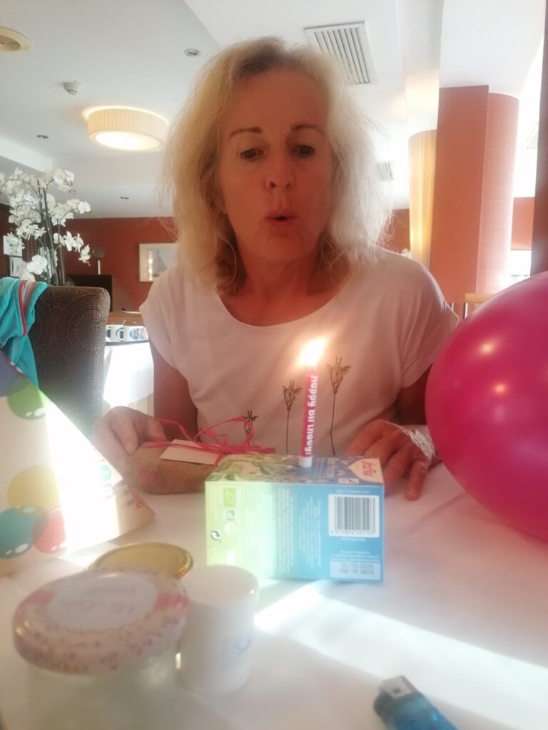 Gitti blast ihre Geburtstagskerze aus, die sich auf einer Teepackung befindet.