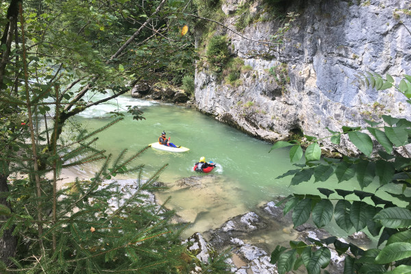 Blick von oben auf Wasser mit zwei kleinen Booten - von Felsen umgeben