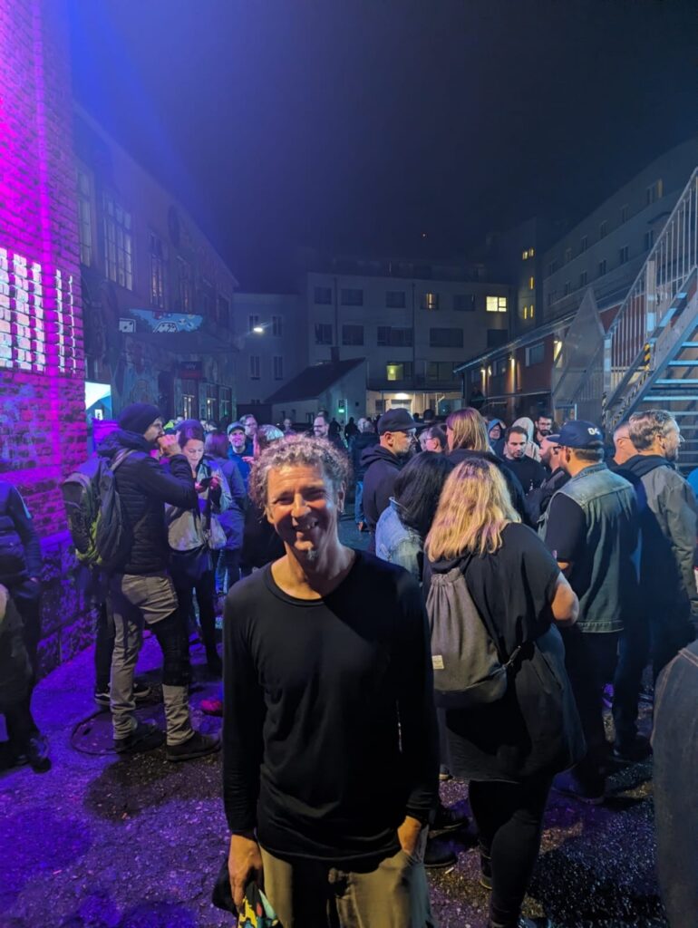 Seppi nachts drauĂen vor der Konzerthalle, im Hintergrund viele Menschen