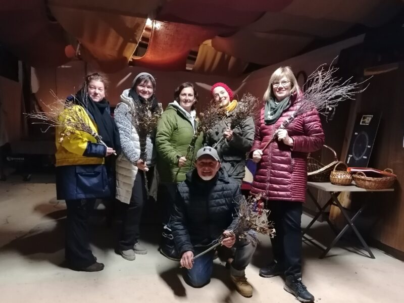 5 Frauen und ein Mann in Jacken mit selbstgebastelten Besen in der Hand