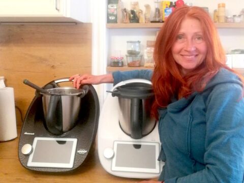 Karin in ihrer Küche mit einem weißen und einem schwarzen Thermomix.