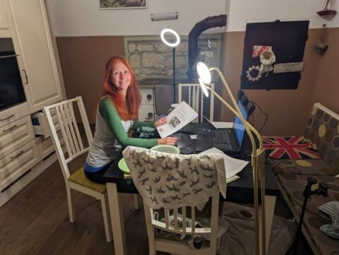 Karin am Küchentisch mit Laptop und Ringlicht