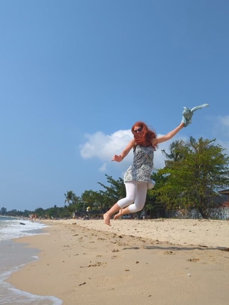 Karin macht einen Luftsprung am Strand