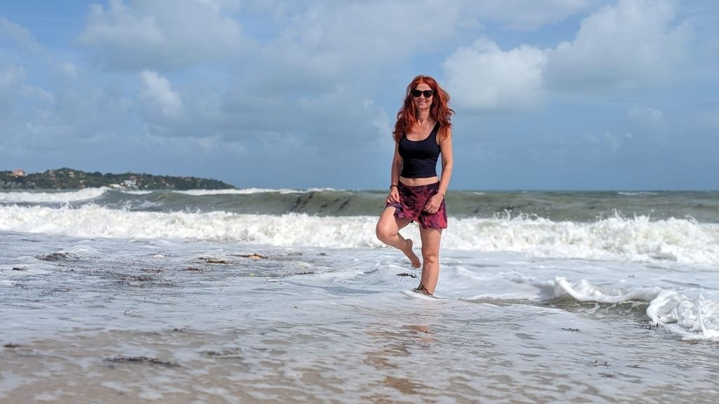 Karin auf einem Bein stehend im Meer