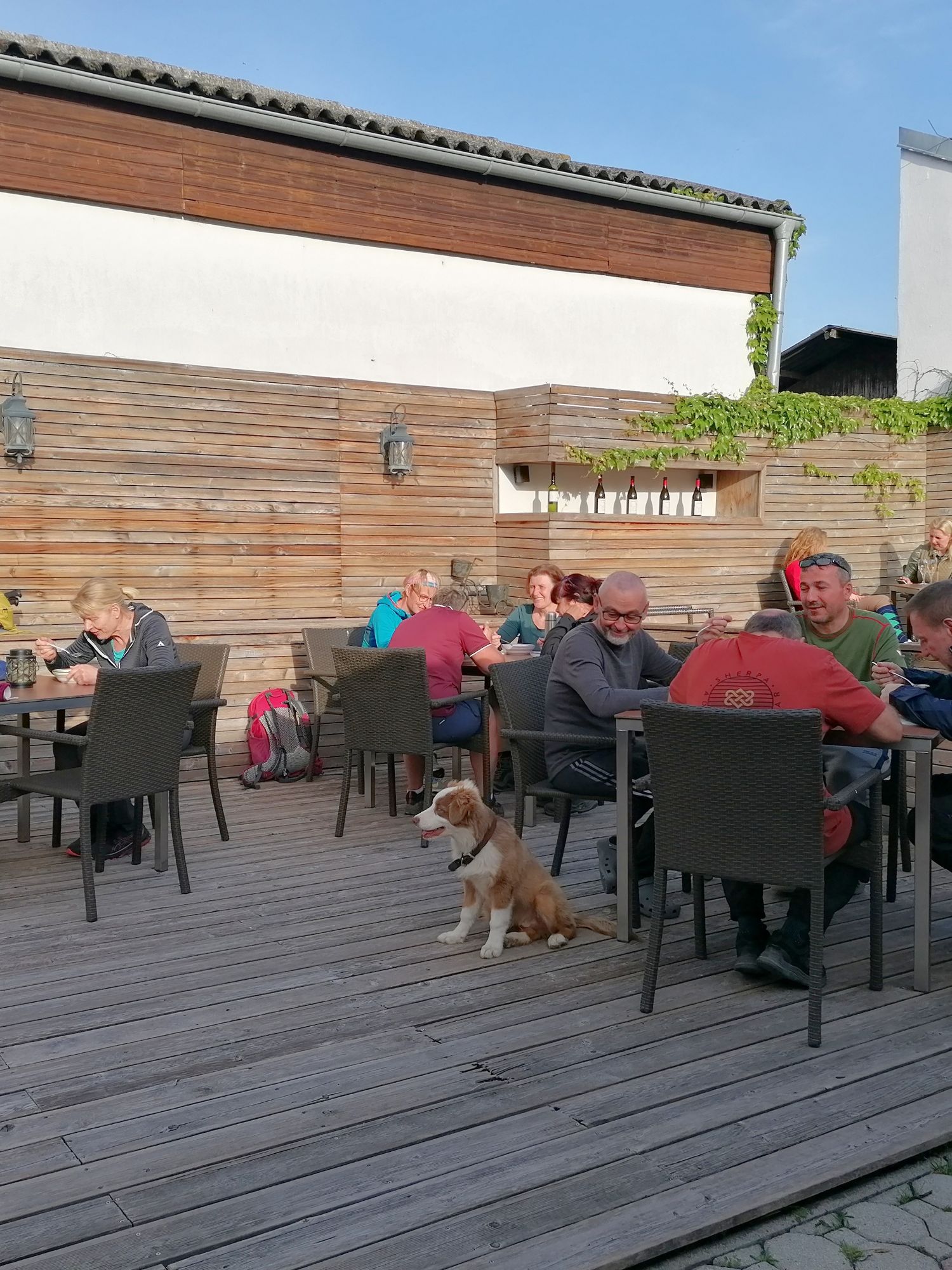 Holzterasse mit Tischen und Leuten - die Fastenwandergruppe beim Suppen-Essen