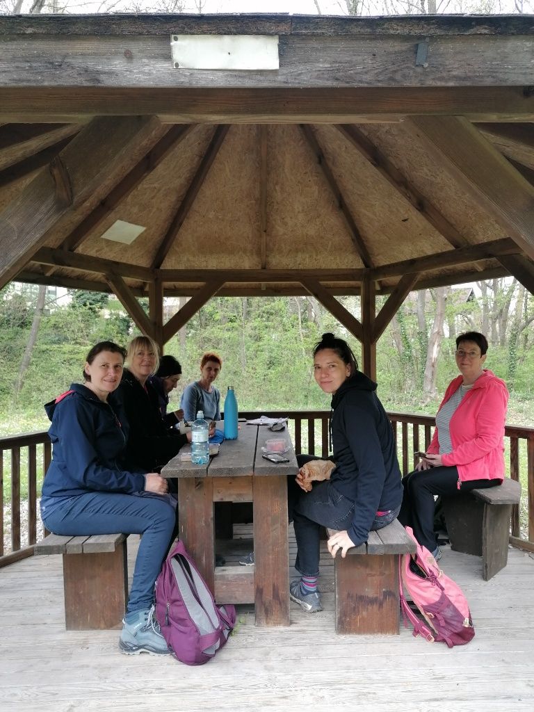 Wandergruppe bei der Rast in einem offenen Holzpavillon