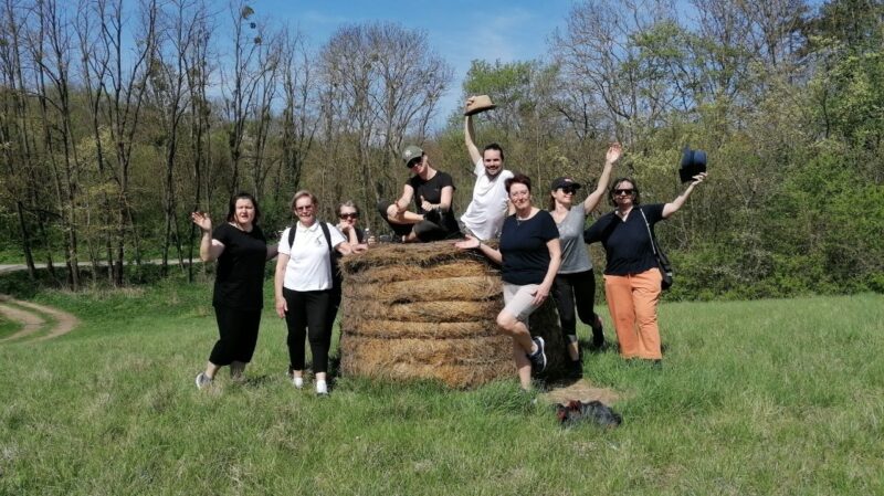 Gruppenbild - 8 Personen am und rund um einen Strohballen