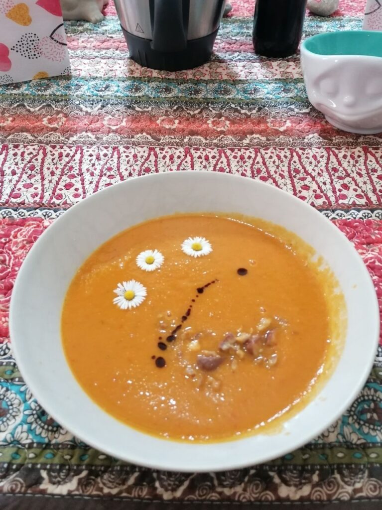 Suppenteller mit Gemüsecremsuppe, garniert mit 3 Gänseblümchen, Maroni und Kürbiskernöl