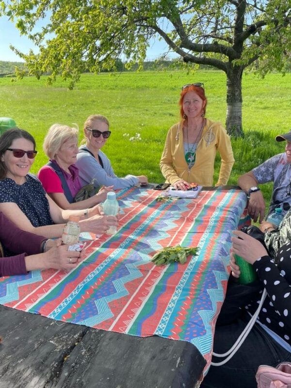 Karin steht am Jausentisch bei ihrer Gruppe