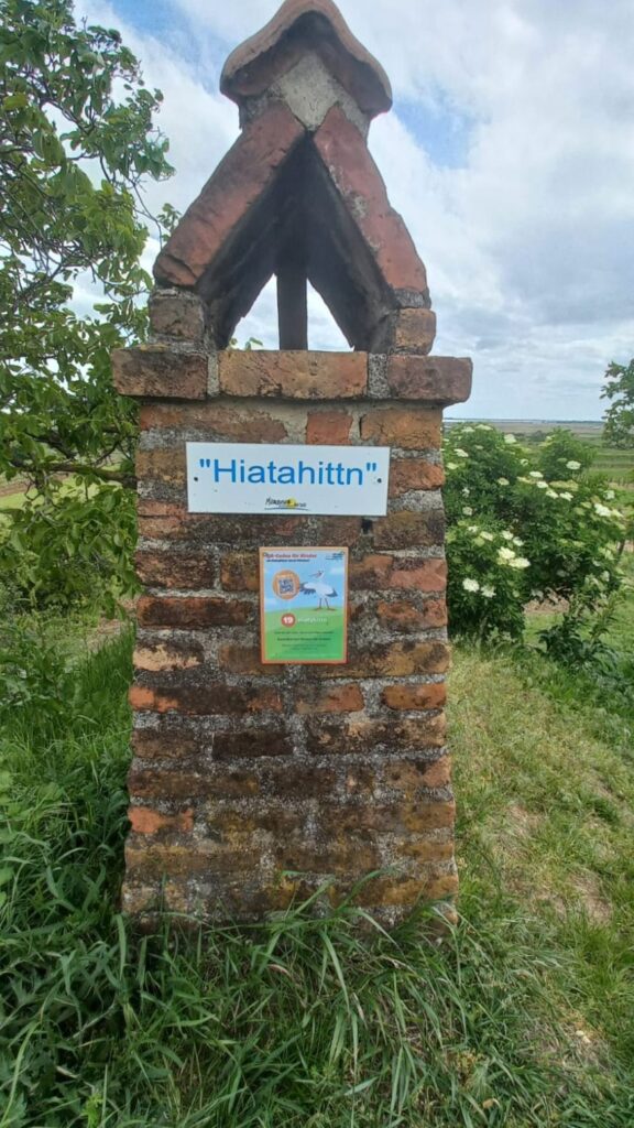 Rauchfangähnliches Gebilde am Wegesrand, mit der Aufschrift "Hiatahittn"