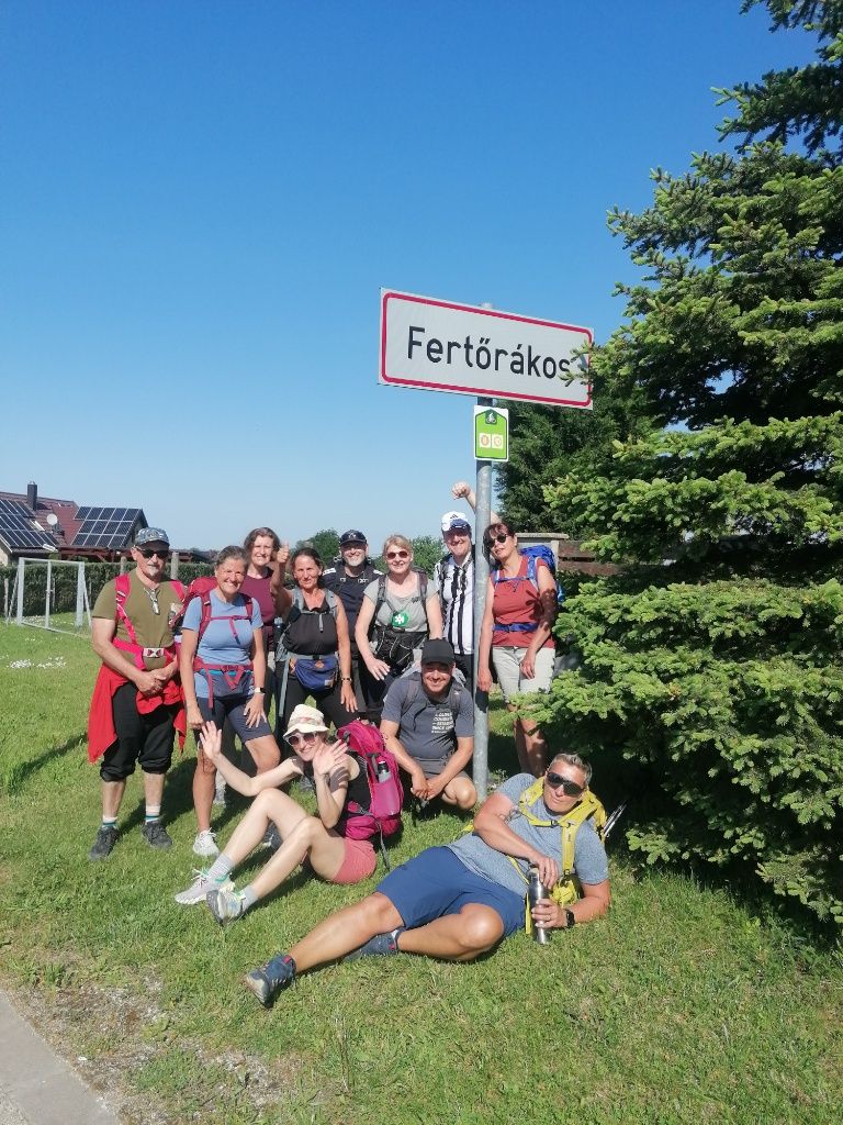 Fastenwandergruppe posieren beim Ortschild von Fertörakos