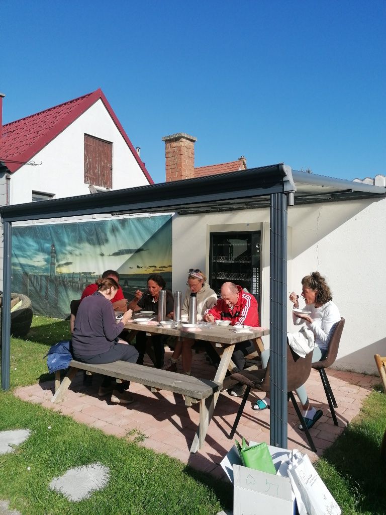 Fastengruppe sitzt im Garten und isst eine Suppe