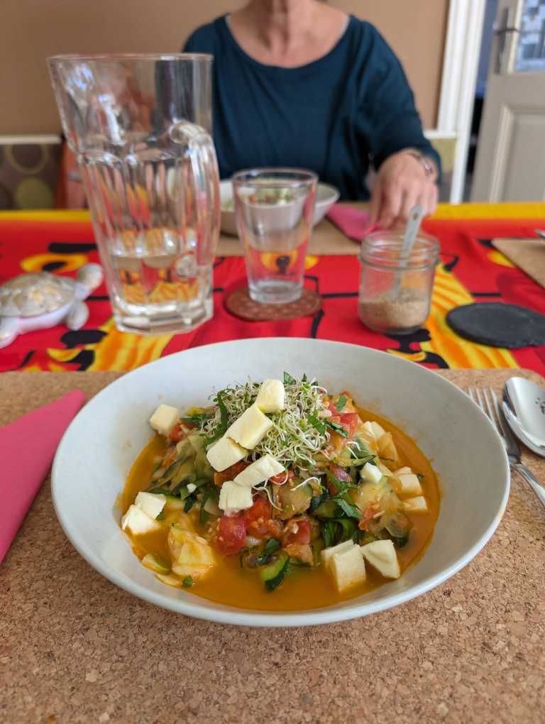 Teller mit Zucchininudeln in Tomatensauce und etwas Mozzarella
