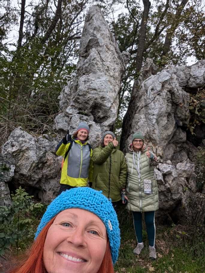 Selfie - Karin mit Fastengruppe im Hintergrund, stehend vor dem Windner Schlüpfstein