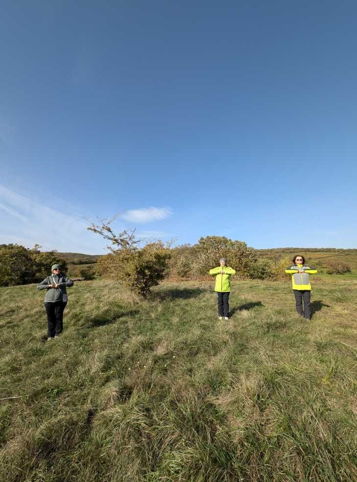 Die drei Teilnehmerinnen beim Praktizieren von Wyda auf einer Wiese stehend