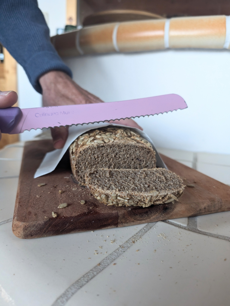 Brot wird mit dem Messer angeschnitten