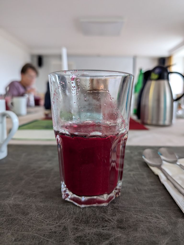 Wasserglas, zur Hälfte mit rotem Saft gefüllt