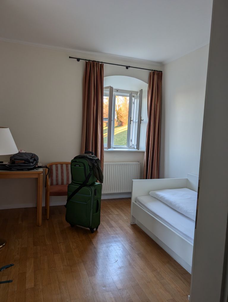 Blick in mein Zimmer mit Einzelbett, Schreibtisch, und altem Holzfenster