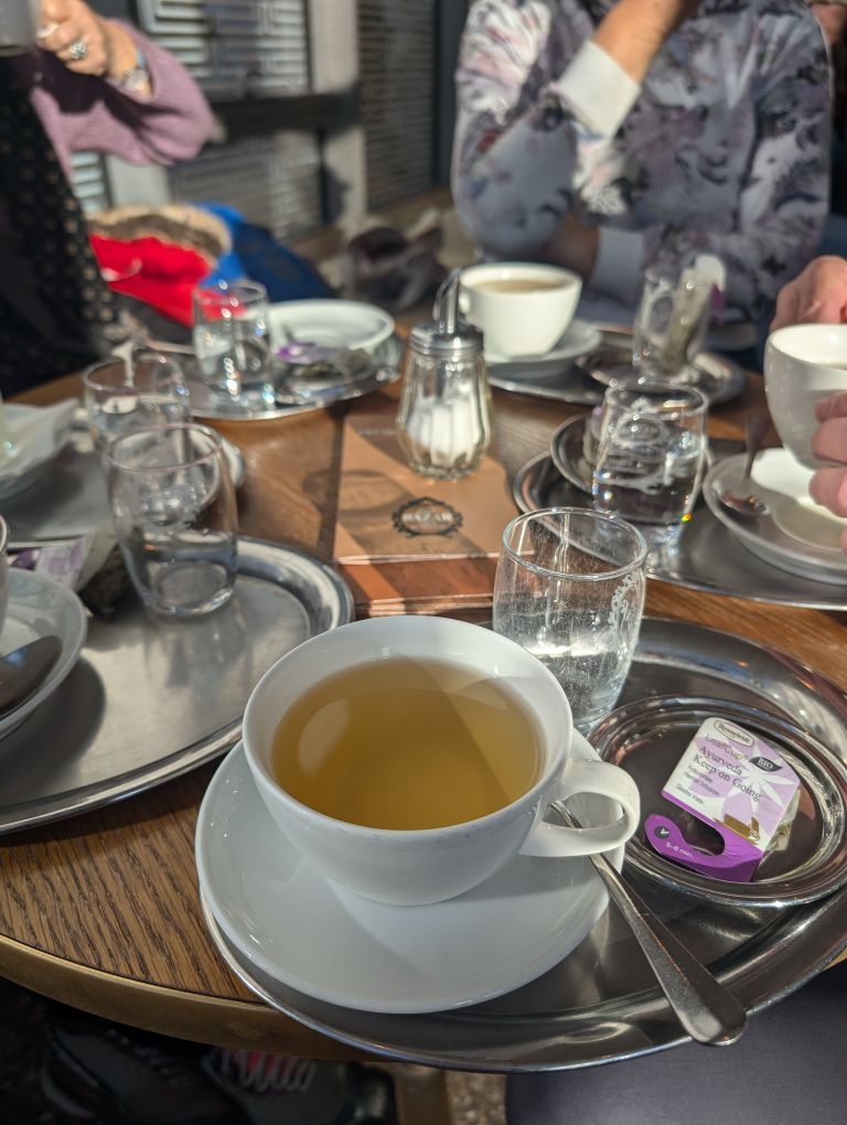 Teetasse mit Kräutertee und vielen anderen Tassen am Tisch