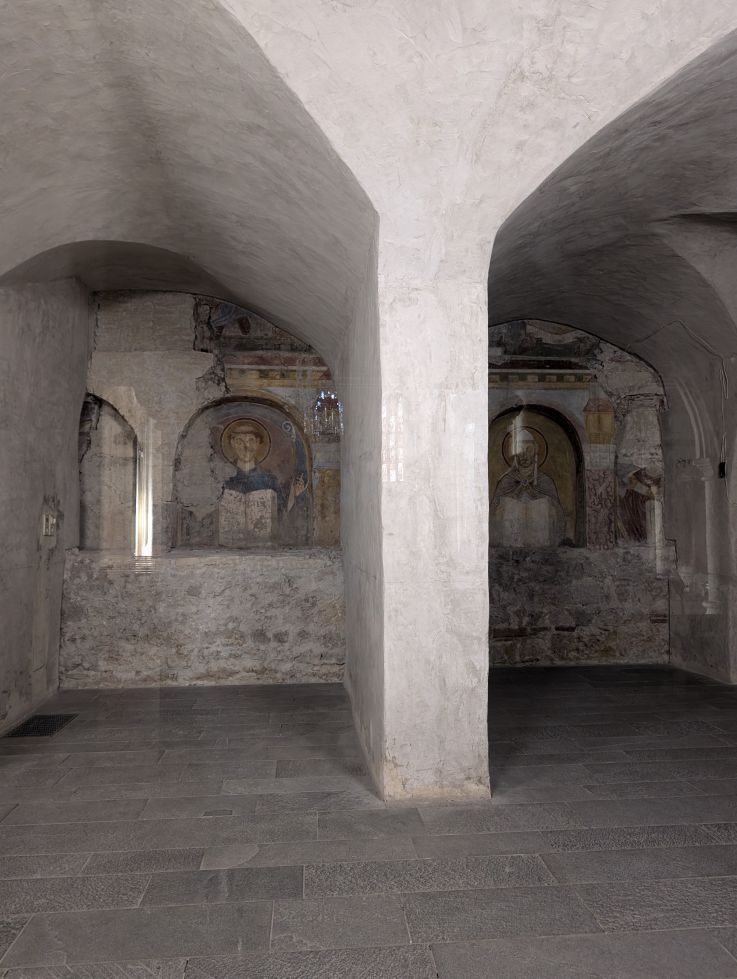 Blick durch die Kirchenbögen auf die Fresken in der Kirchenwand
