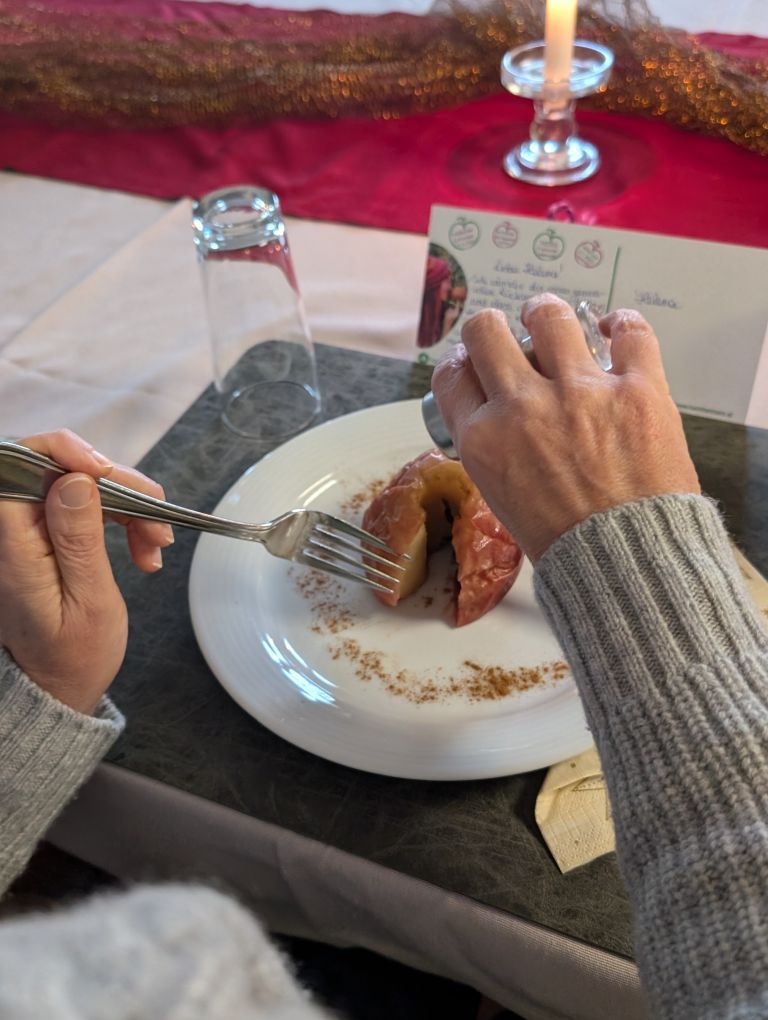 Bratapfel auf dem Teller, wird gerade angeschnitten