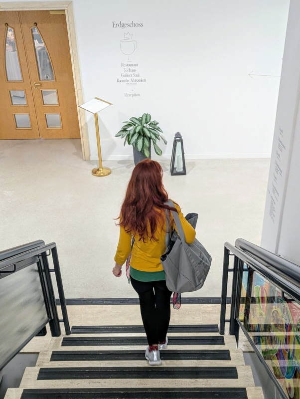Karin von hinten, wie sie die Treppe runter geht.