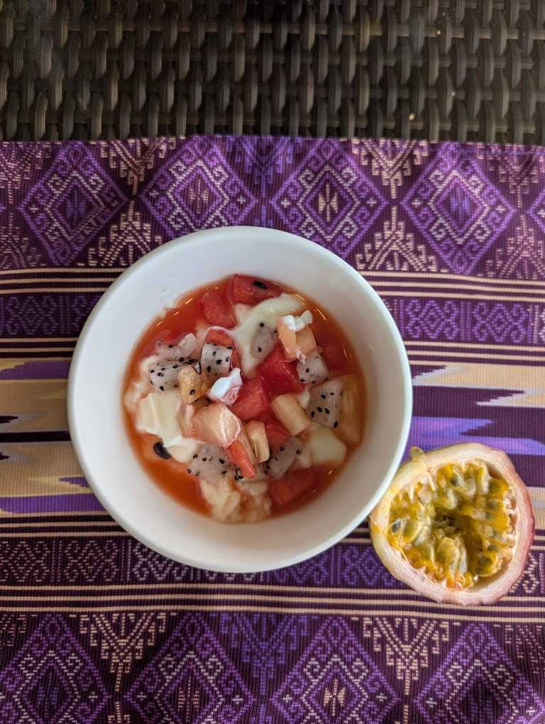 Schüssel mit Fruchtsalat, daneben eine halbe Passionsfrucht