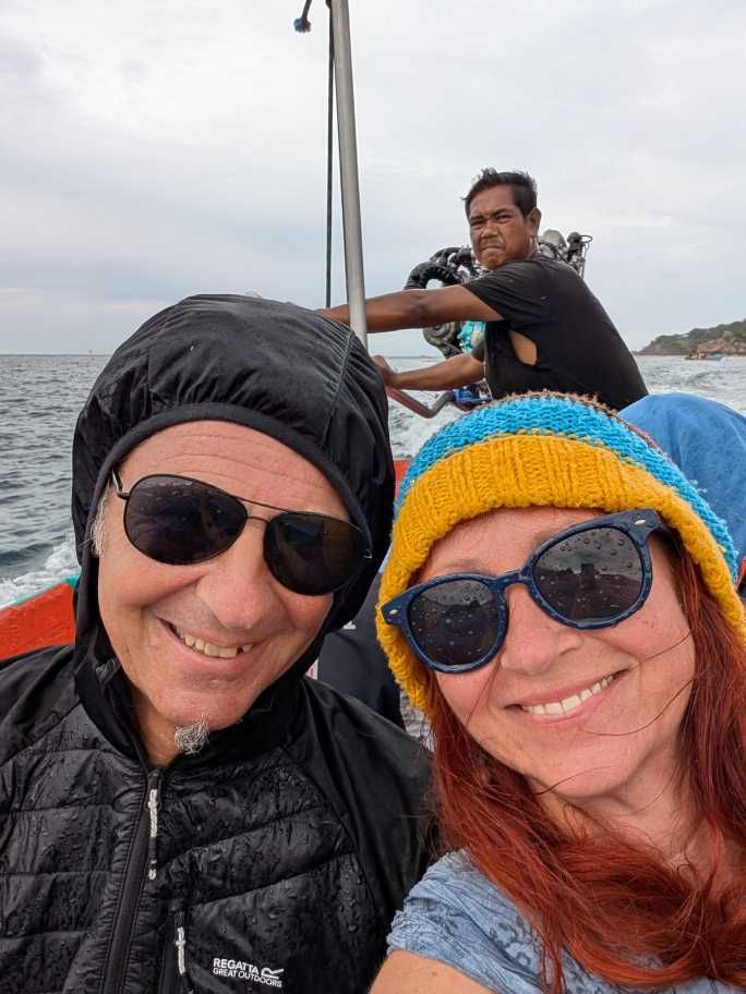Seppi und Karin mit Kapuze, Haube und nasse Sonnenbrillen im Boot