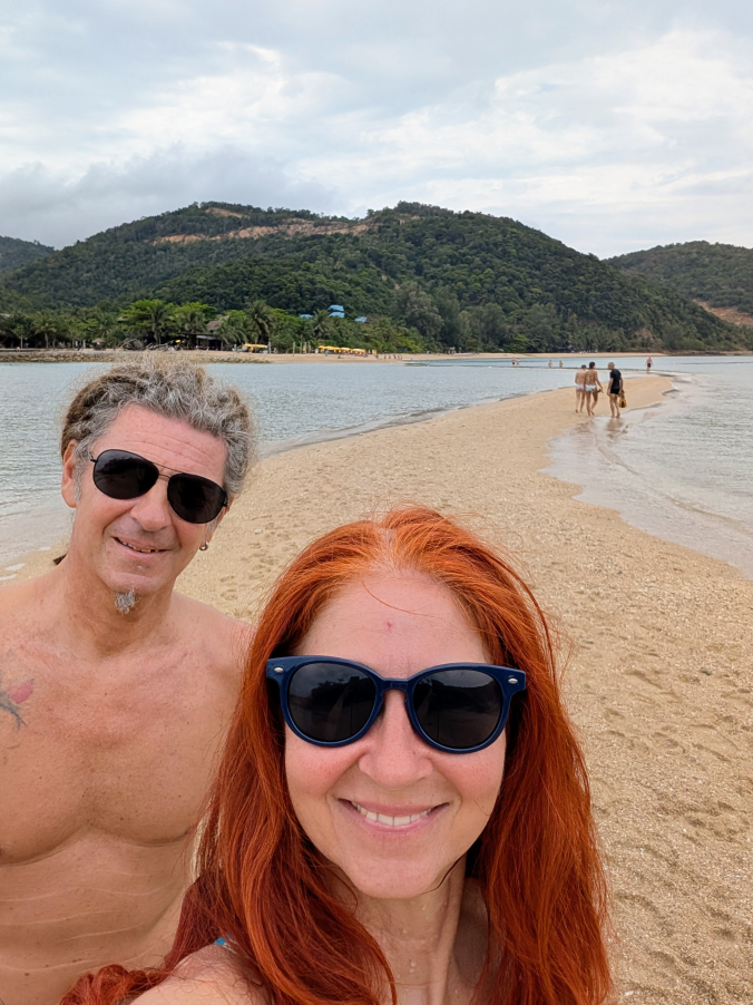 Karin und Seppi - Selfie - im Hintergrund die Sandbank, die wie ein Weg zurück aufs Festland führt