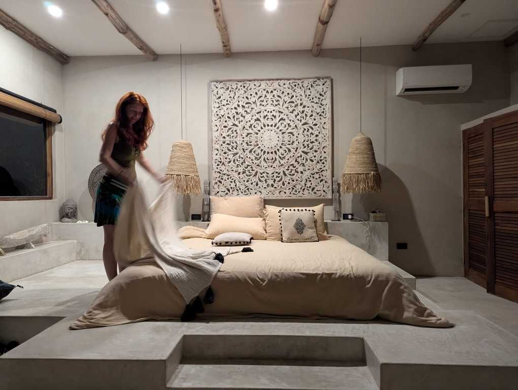 Karin beim Betten machen in einem traumhaft, gemütlich-modernen Zimmer