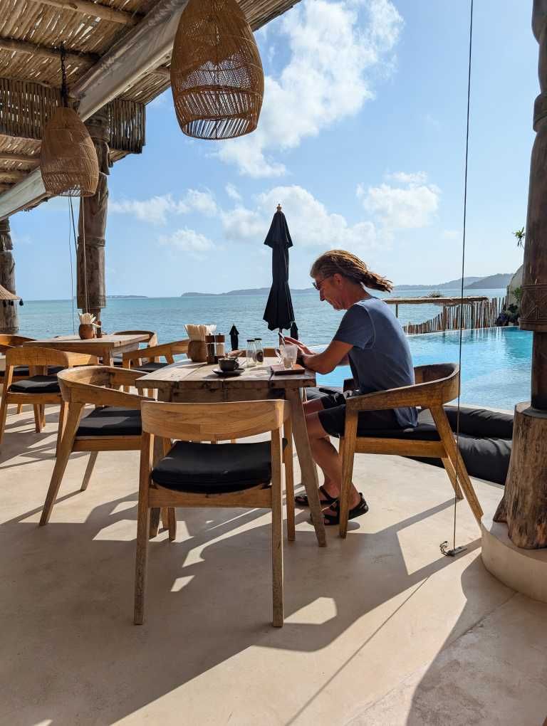 Seppi am Frühstückstisch, im Hintergrund der Pool und das Meer