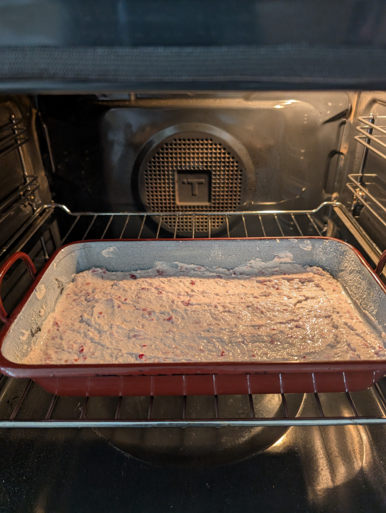 Kuchenform mit rohem Teig im Backrohr