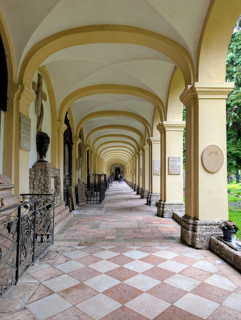 Steinweg unter Arkaden, links Grabsteine