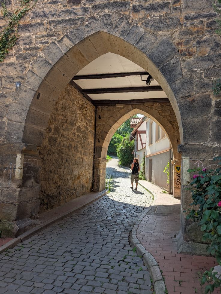 Seppi geht durch einen Stadttorbogen