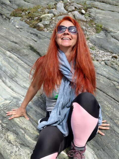 Karin am Felsen sitzend, mit Freude im Gesicht