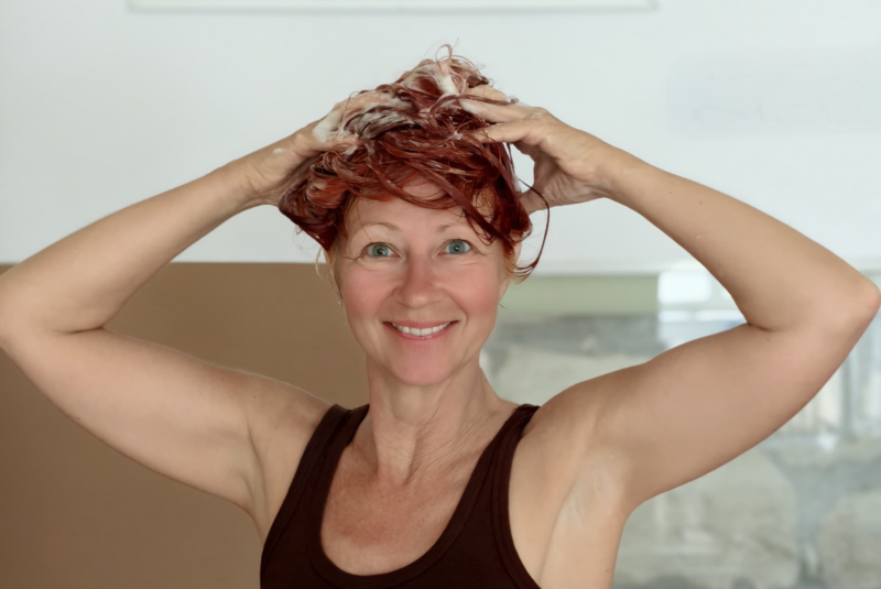 Karin schäumt sich mit beiden Händen ihr rotes Haar ein