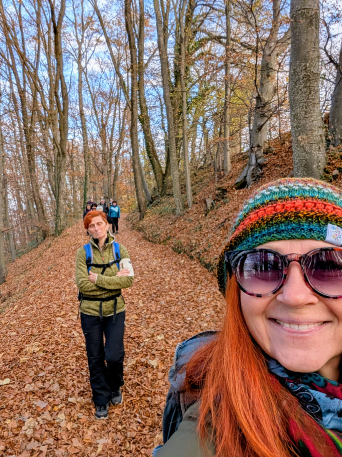 Karin im Vordergrund, dahinter die Gruppe und buntes Herbstlaub am Boden