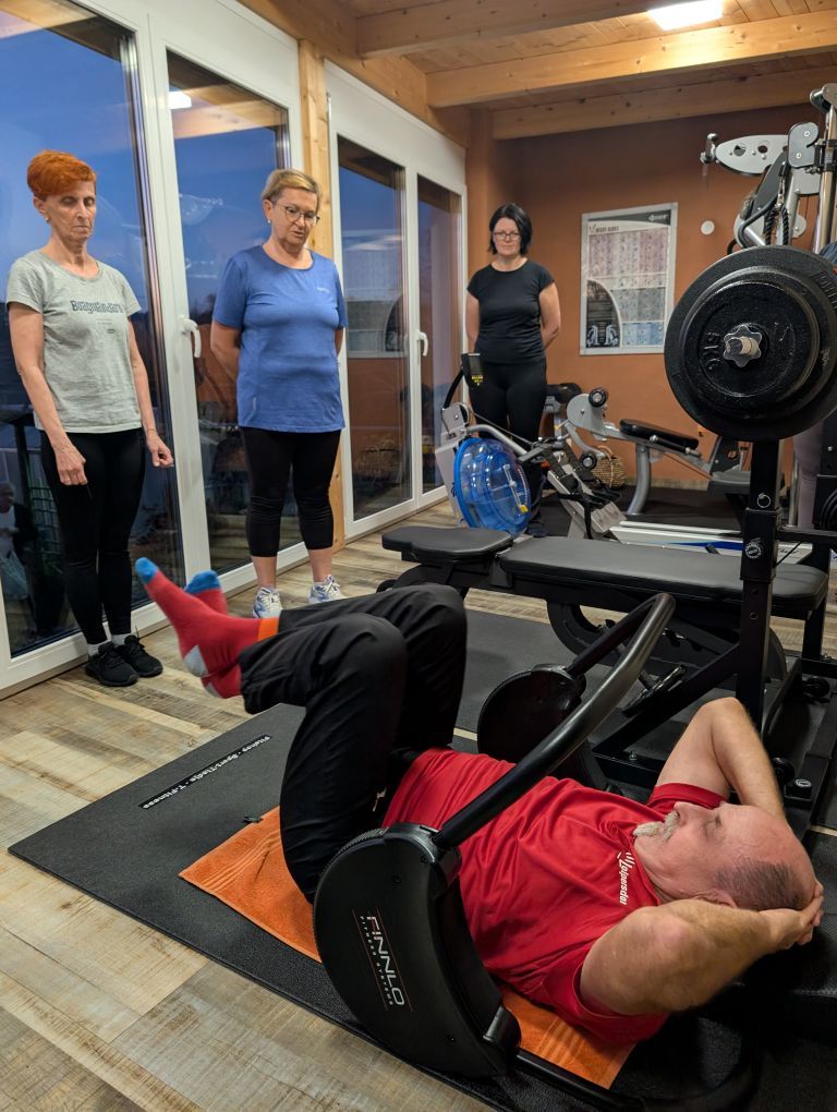 3 Frauen schauen Herbert Uitz beim Fitnesstraining zu