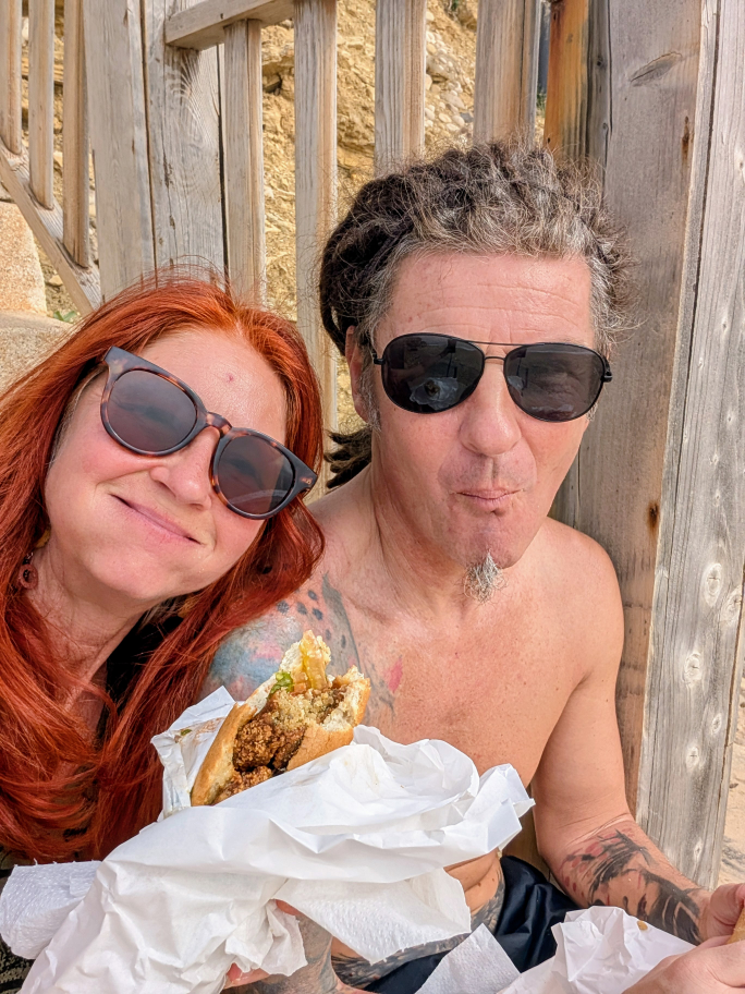 Karin und Seppi mit vollgestopften Mündern und einem Falafel-Sandwich in der Hand.