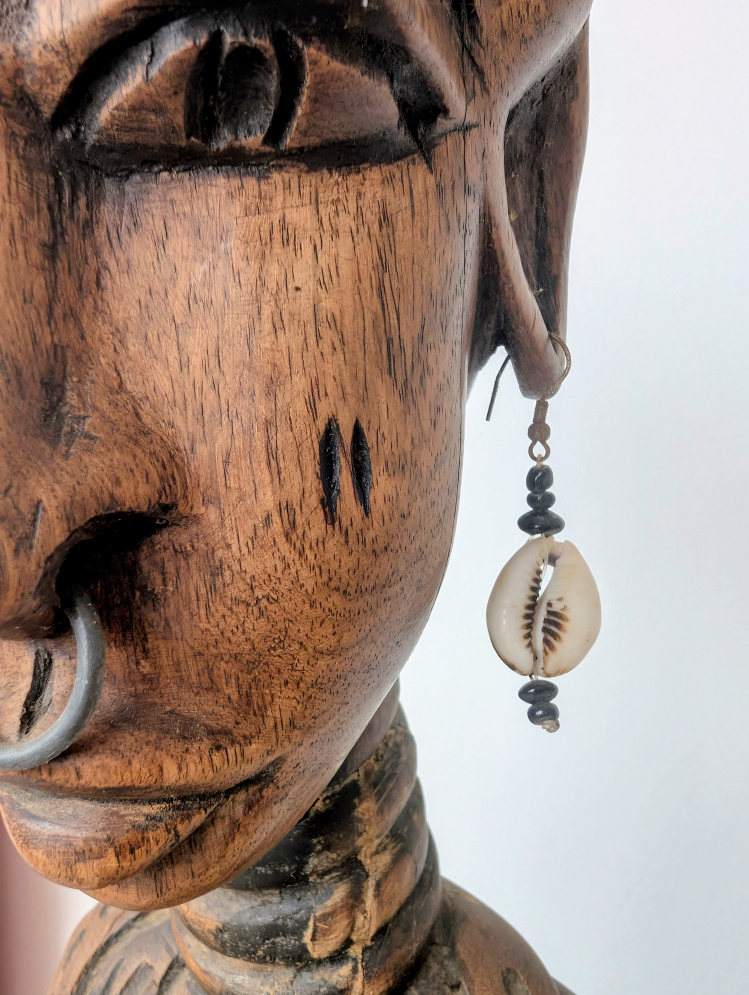 Kopf einer Holzfigur mit Ohrring