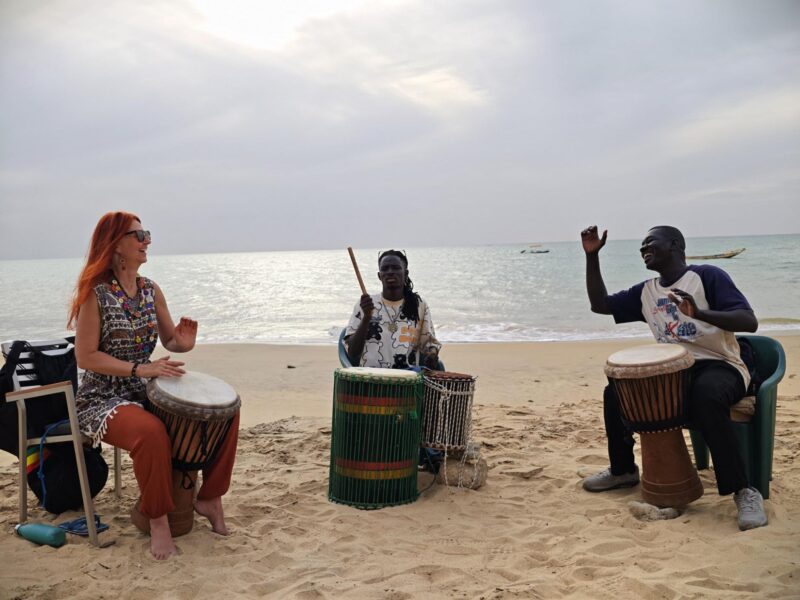 Karin mit ihren Trommellehrern am Strand