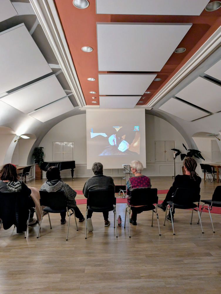 Fastengruppe blickt auf eine Leinwand