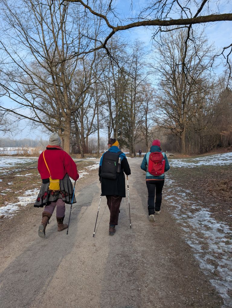 Drei bunt gekleidete, wandernde Frauen von hinten.