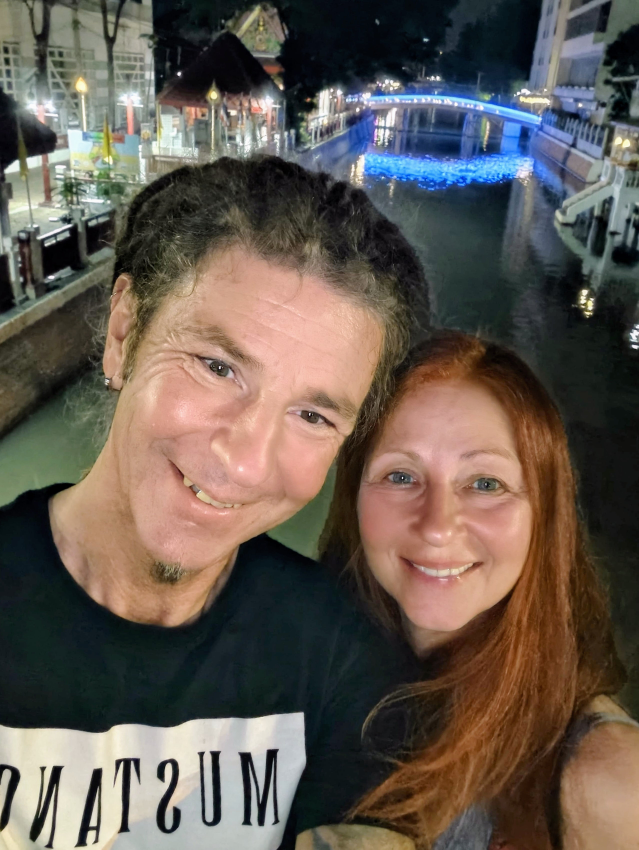Selfie Seppi und Karin, abends auf einer Brücke, im Hintergrund der Fluss