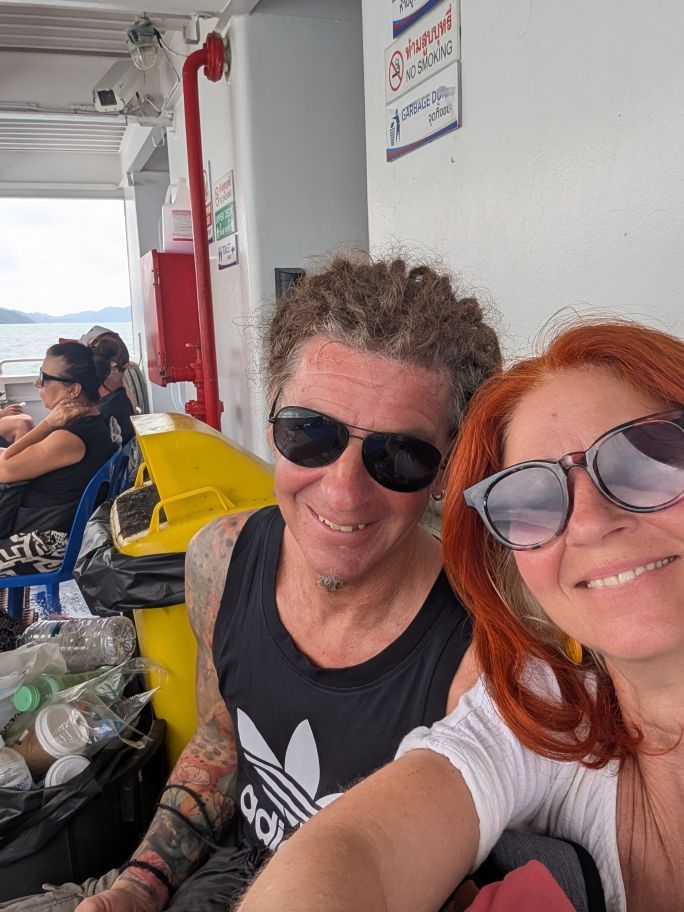 Selfie Seppi und Karin auf der Fähre, sitzend neben Mülltonnen